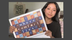 Xiara holding the 2026 calendar with her artwork showing